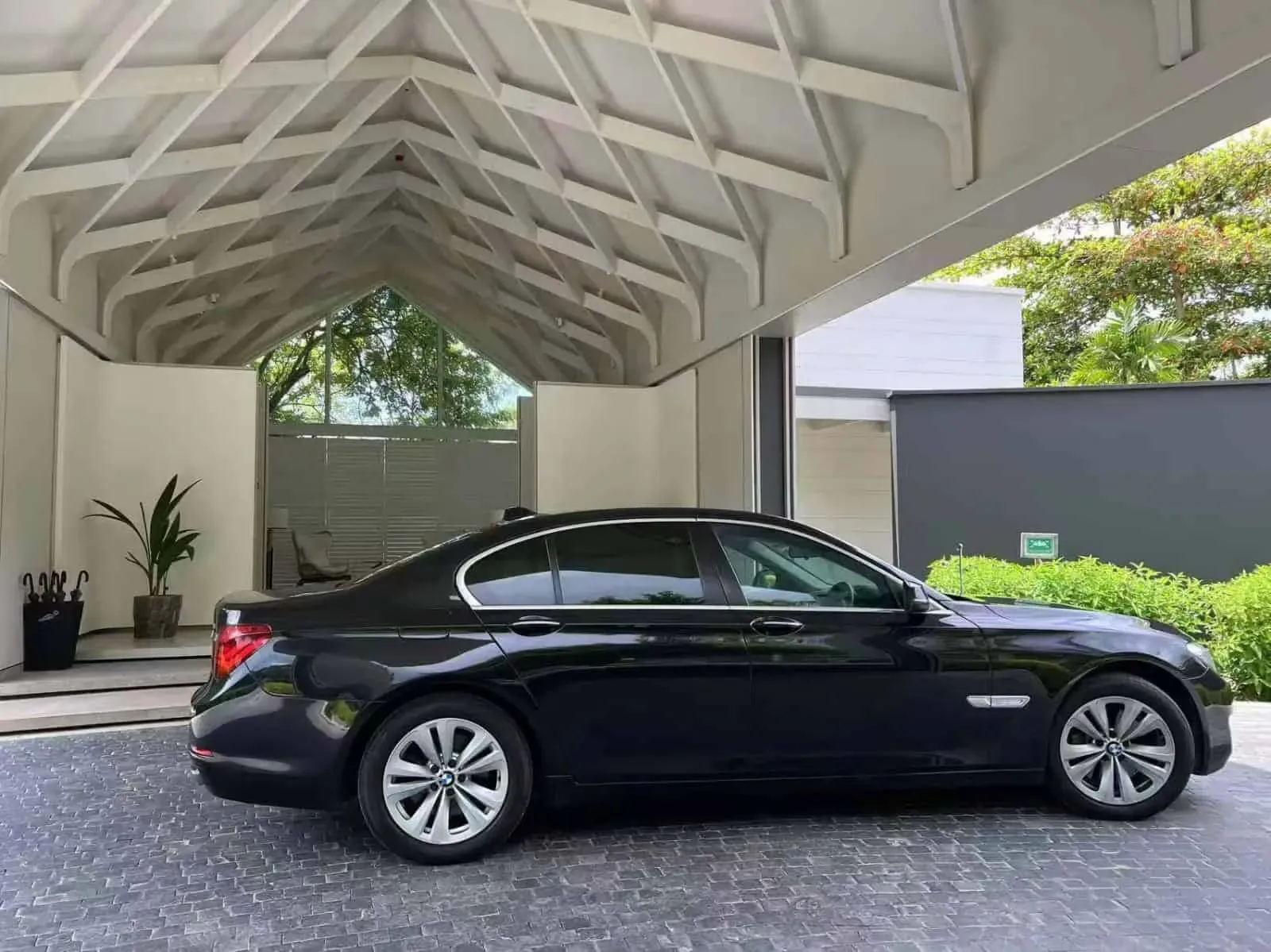 Luxury VIP transfer car parked under modern driveway canopy