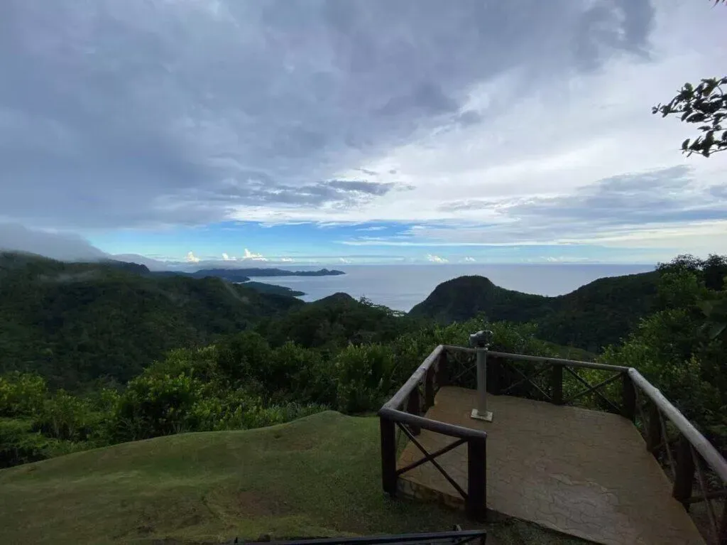 Mission Lodge viewpoint with scenic overlook, lush green hills, and panoramic views of the ocean in Seychelles.